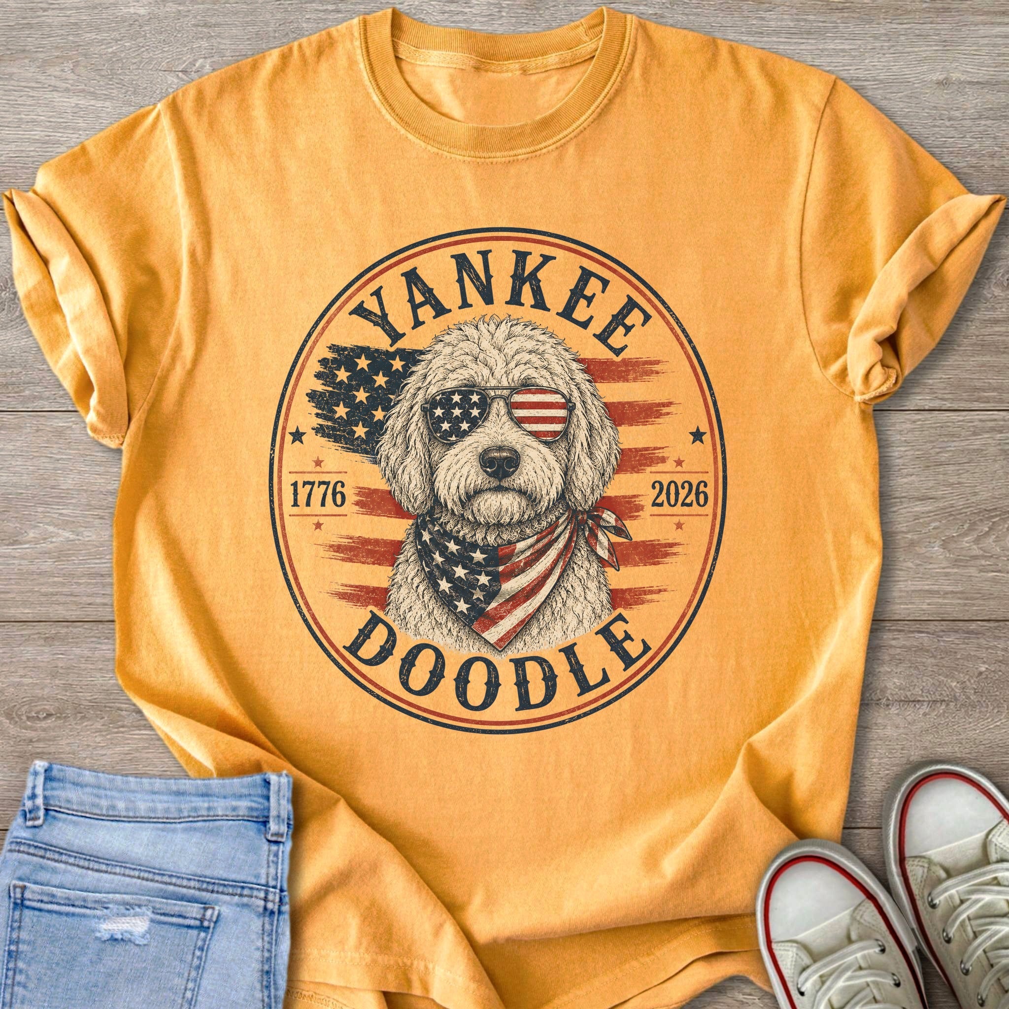 Gold t-shirt with a Doodle dog wearing patriotic sunglasses and bandana.