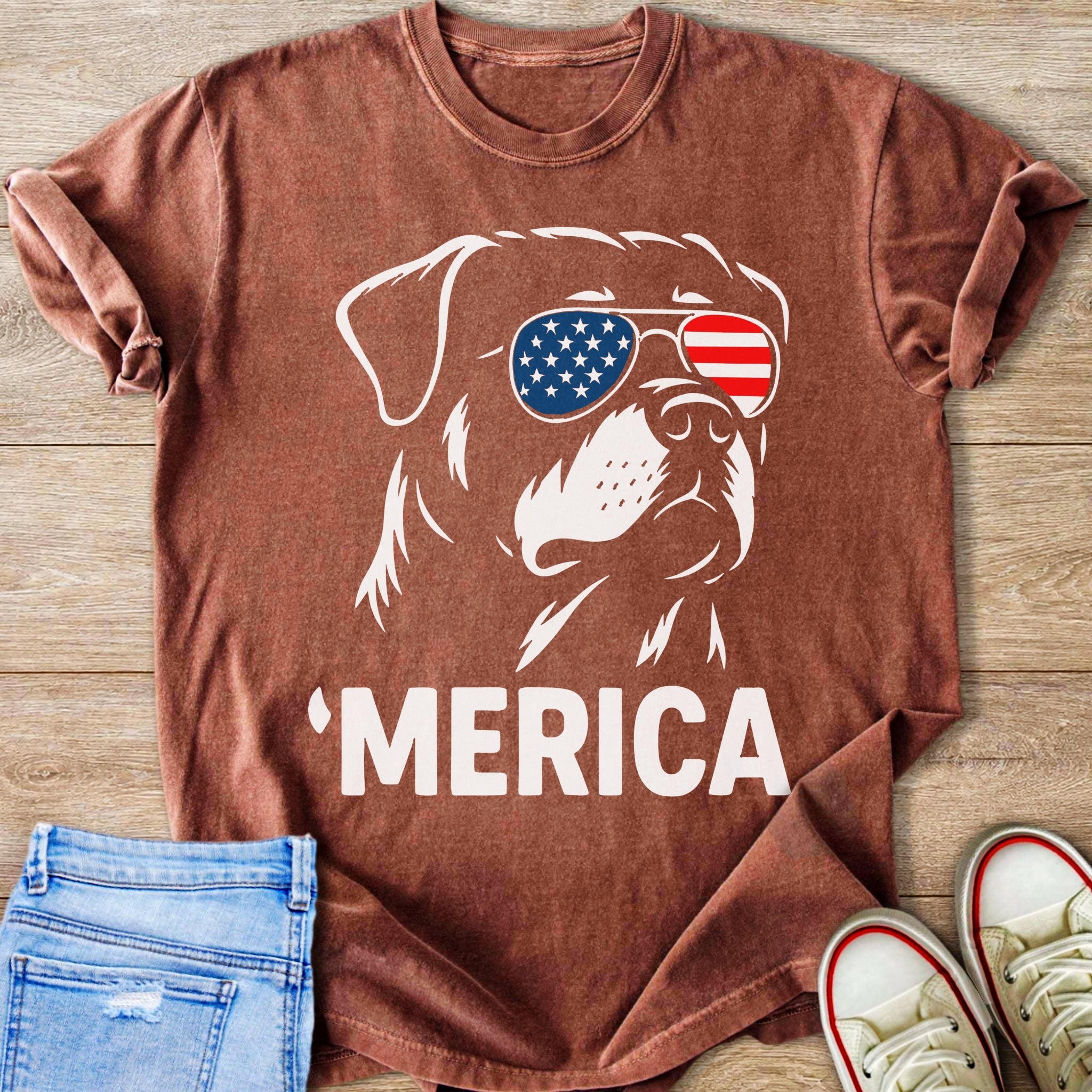 Brown t-shirt with a white outline of a dog wearing American flag sunglasses and text 'MERICA.