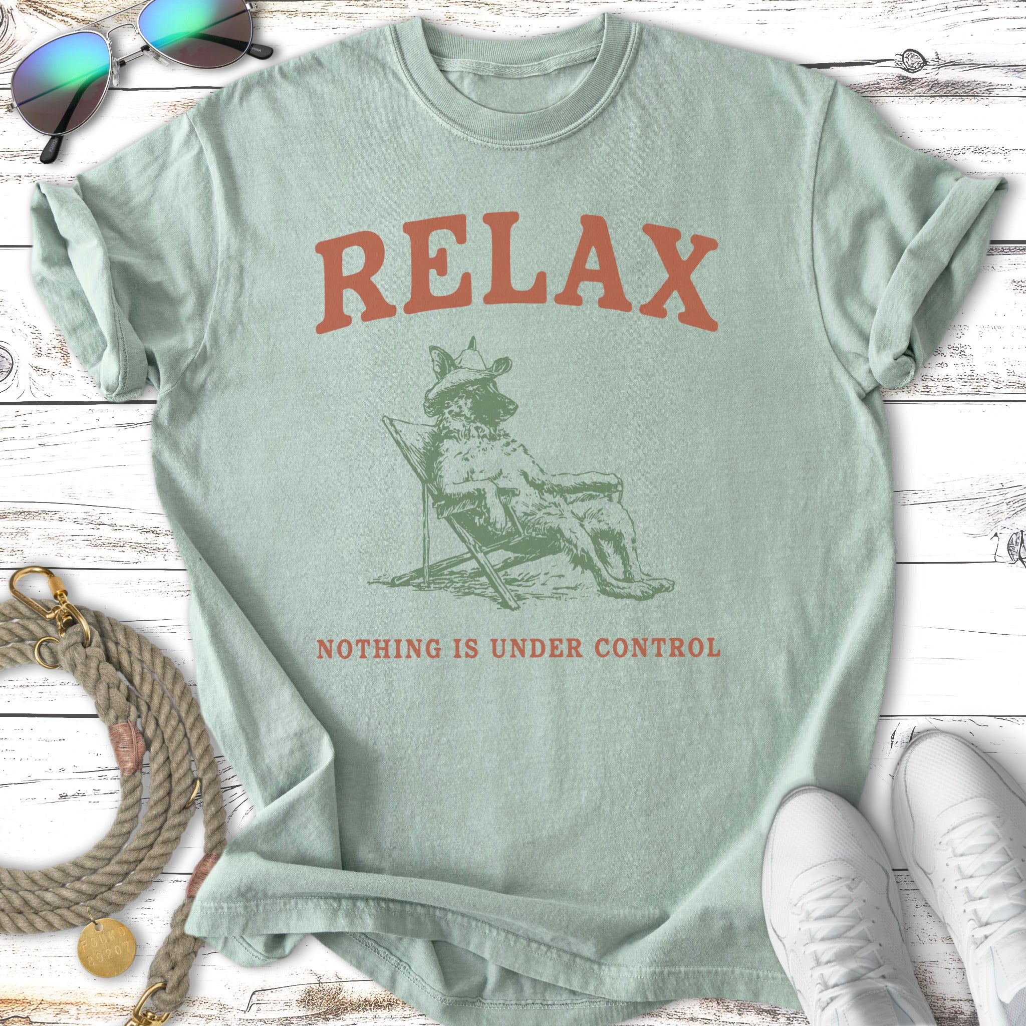 Green t-shirt with a dog in a cowboy hat on a beach chair, text reads RELAX NOTHING IS UNDER CONTROL.