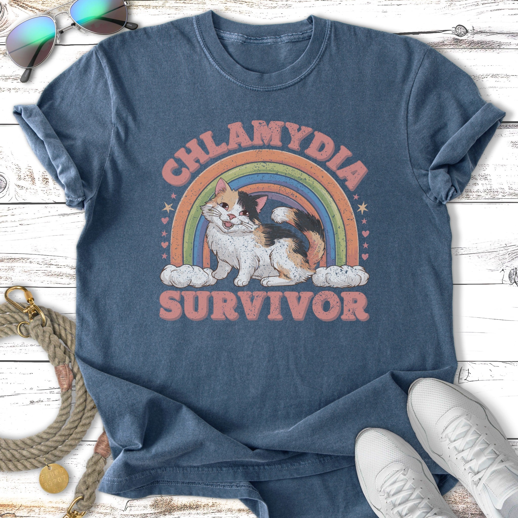 T-shirt with cat and "Chlamydia Survivor" text, rainbow, and clouds.