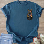 German Shepherd wearing patriotic sunglasses and bandana peeking from a pocket.