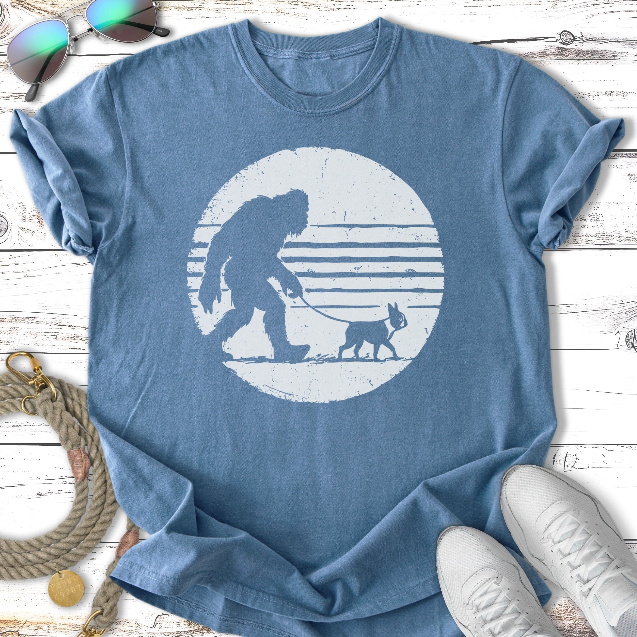 Bigfoot walking a Boston Terrier on a leash, depicted in a circle.