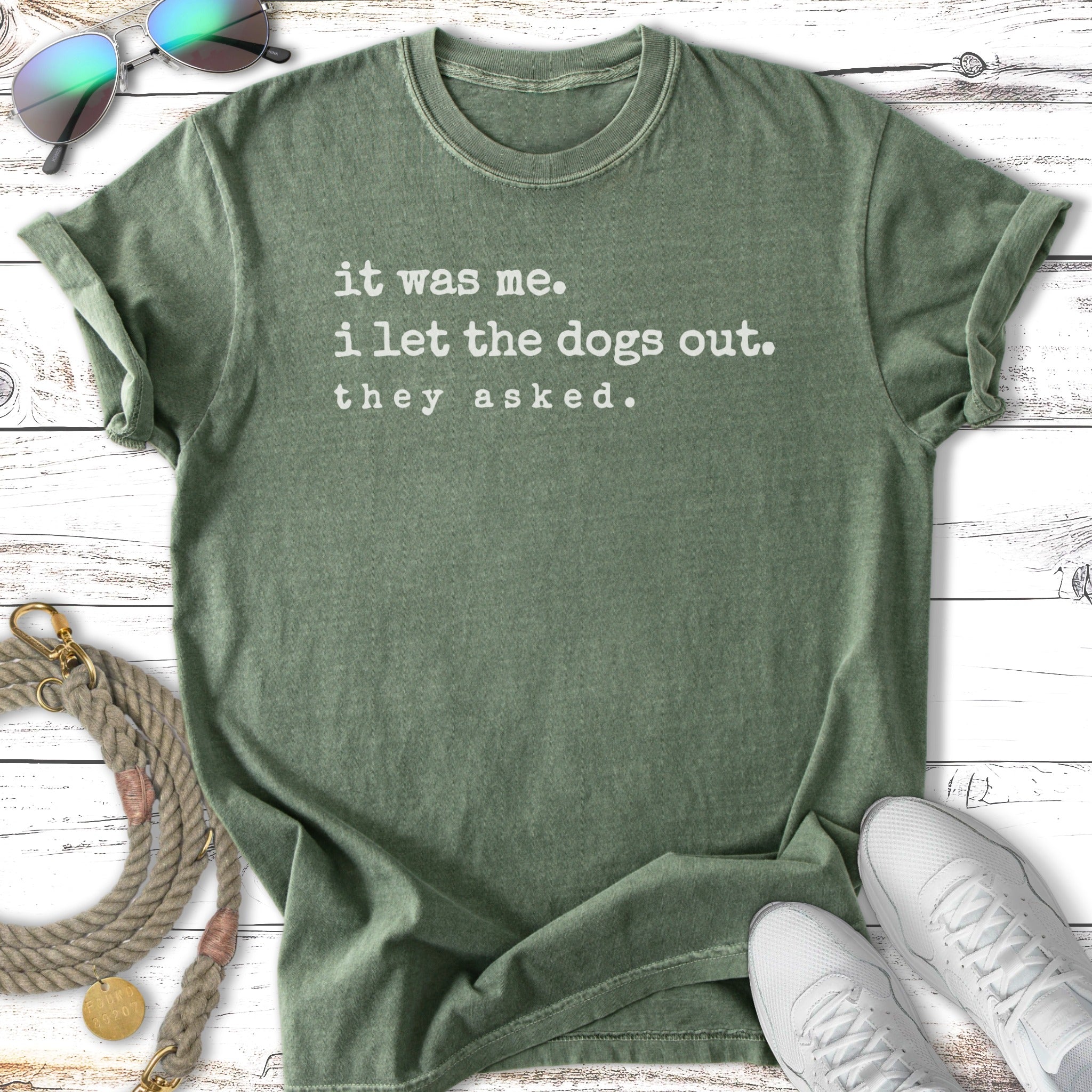 Green t-shirt with white text: "it was me. i let the dogs out. they asked."