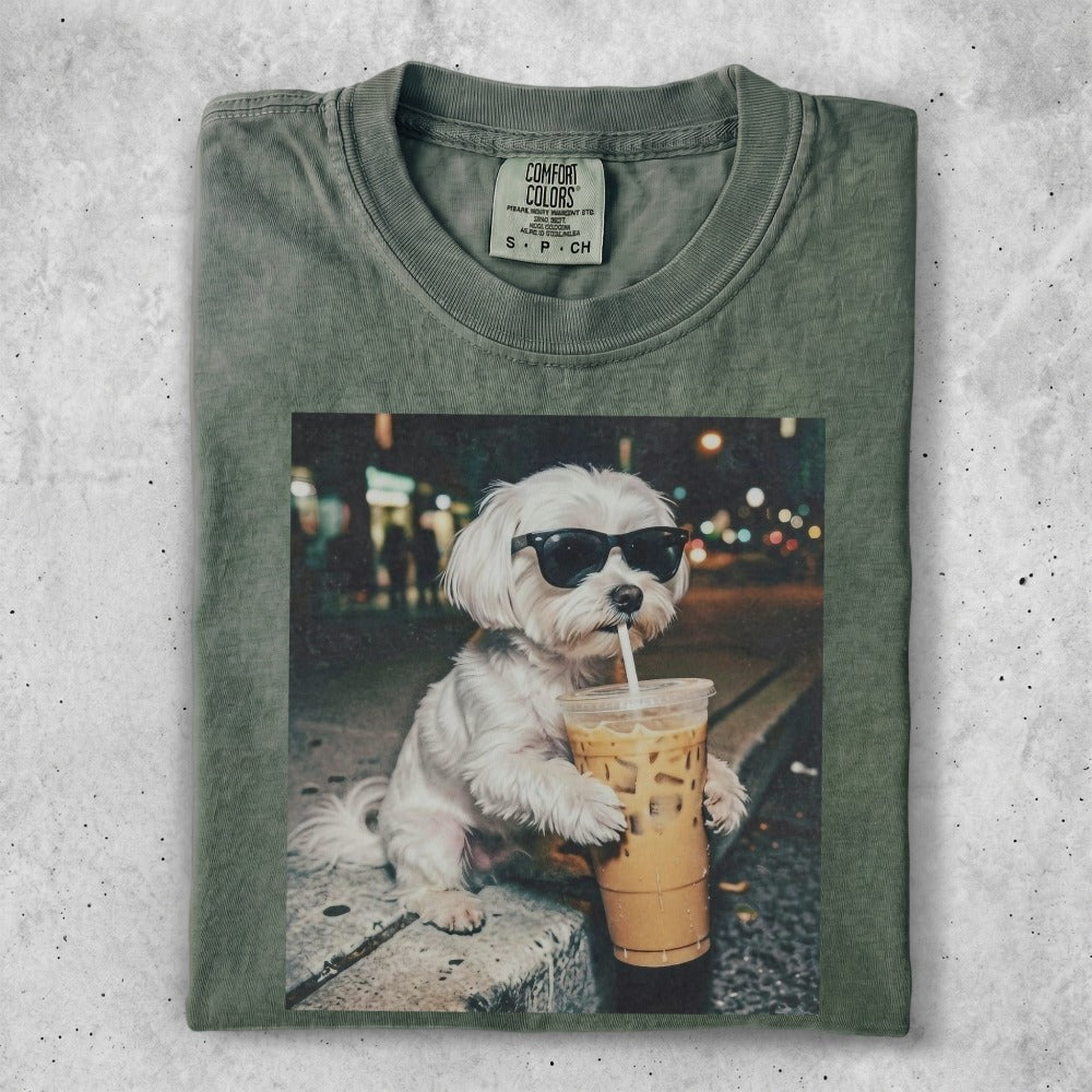 White dog wearing sunglasses drinks iced coffee.