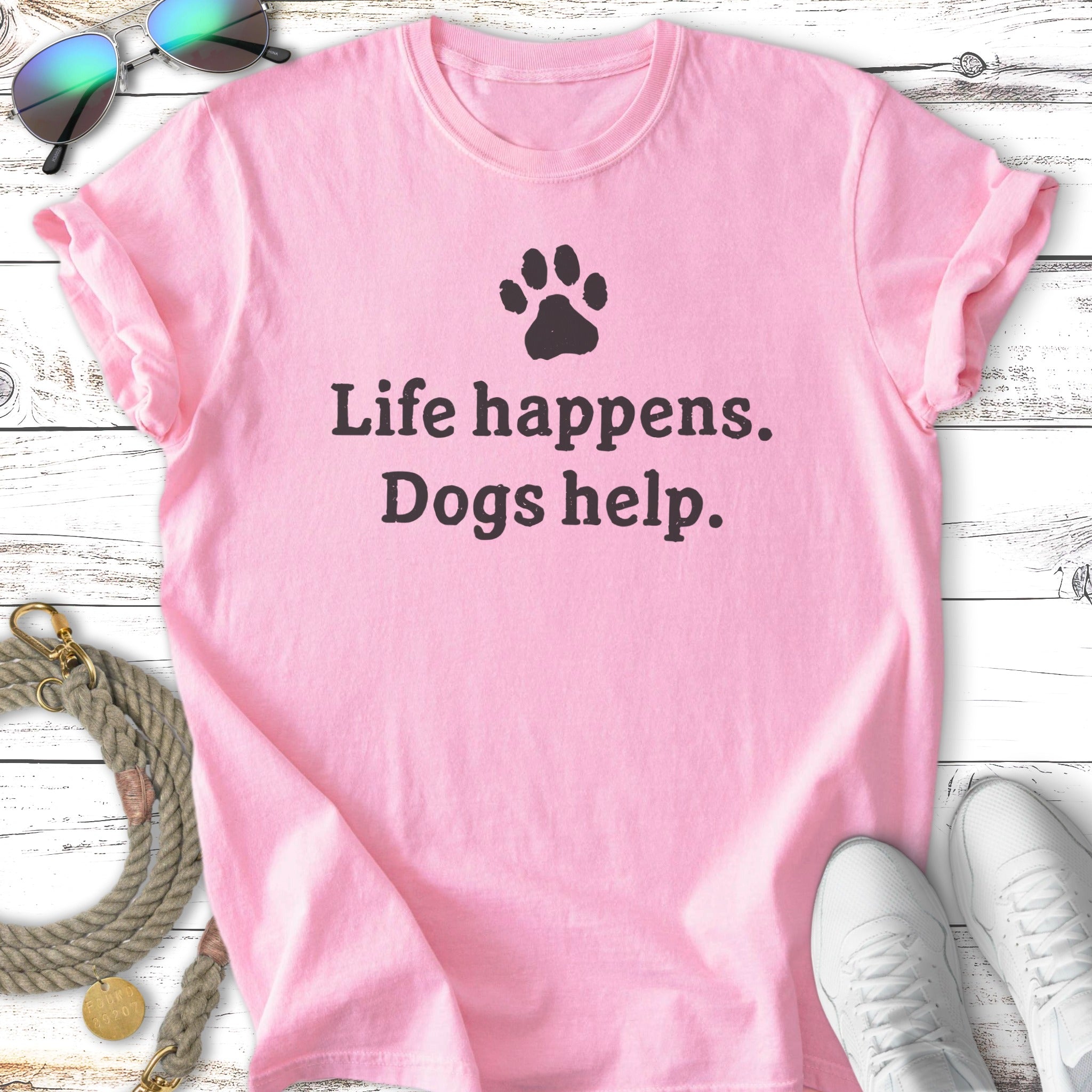 Pink t-shirt with "Life happens. Dogs help." text and paw print.