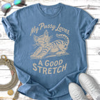 Blue t-shirt with a graphic of a stretching cat and text "My Pussy Loves. A GOOD STRETCH."