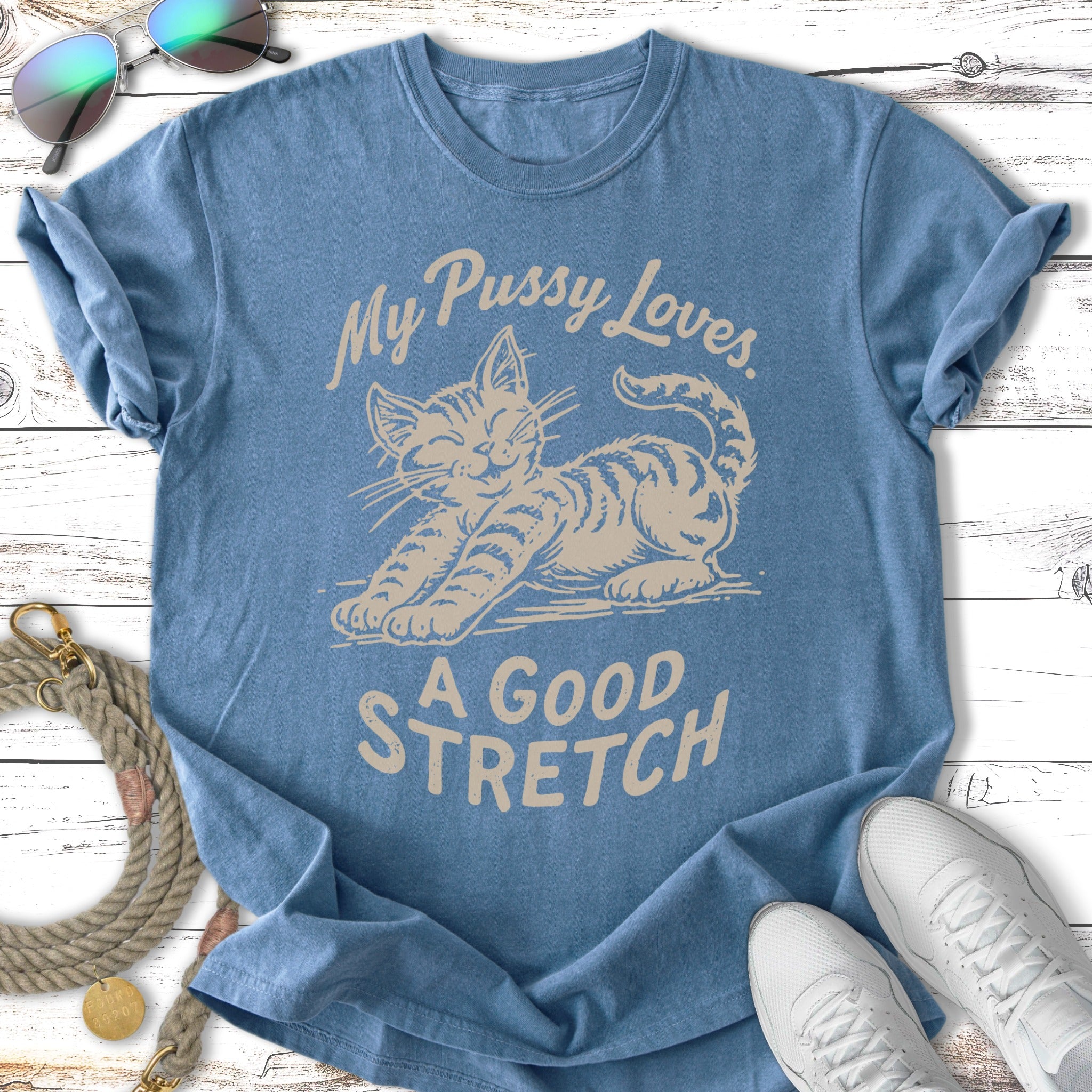 Blue t-shirt with a graphic of a stretching cat and text "My Pussy Loves. A GOOD STRETCH."