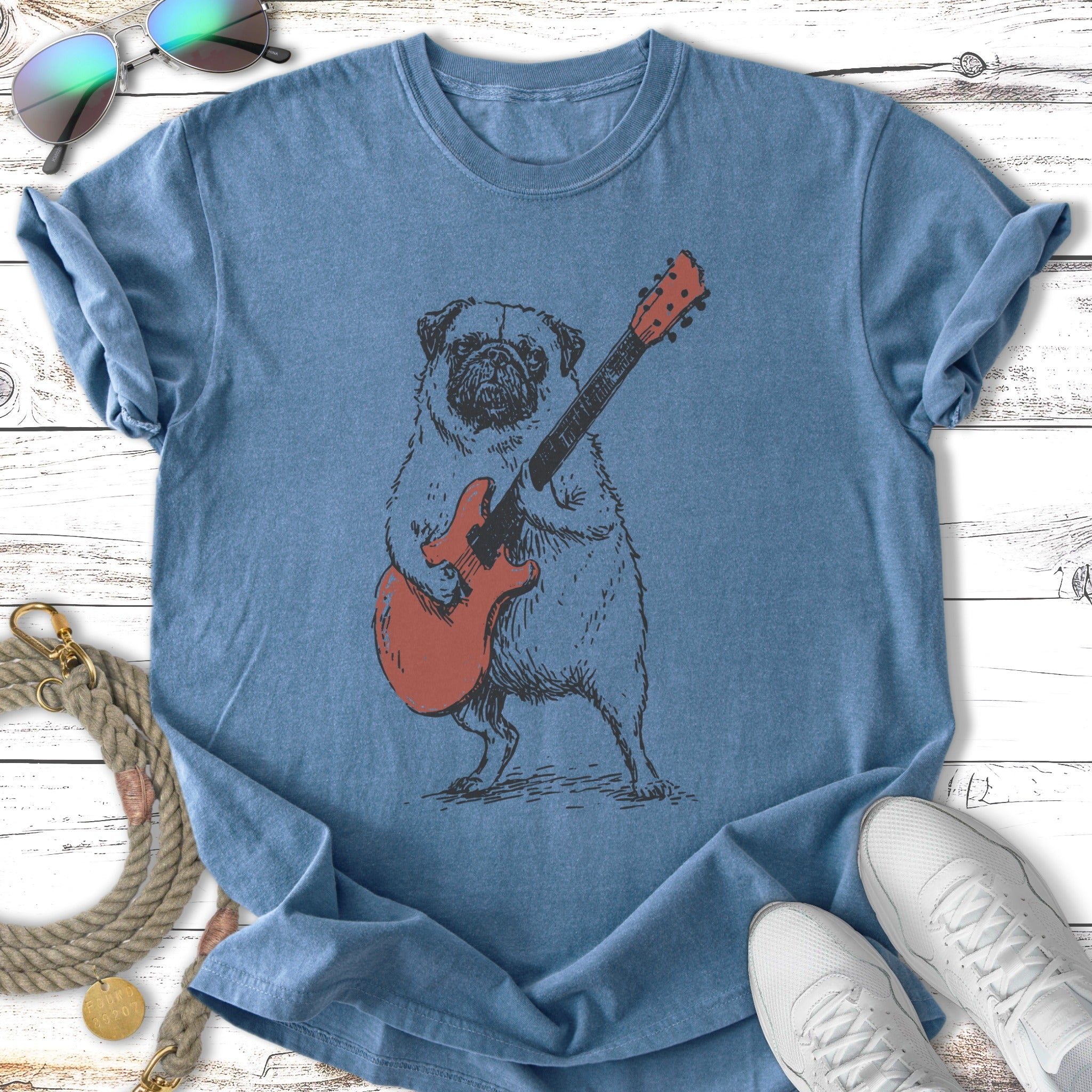 Pug playing a red electric guitar, on a blue t-shirt.