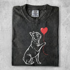 French bulldog holding a red heart balloon.
