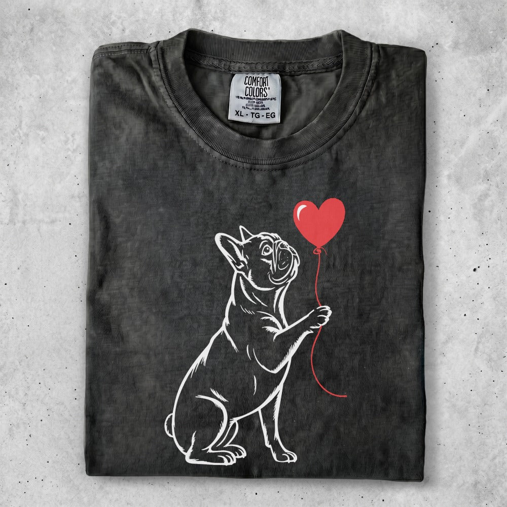 French bulldog holding a red heart balloon.