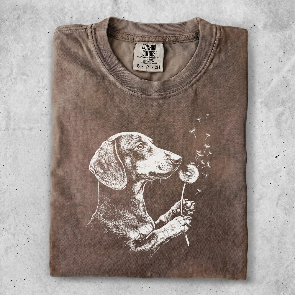 Brown t-shirt with dachshund holding dandelion and blowing seeds.