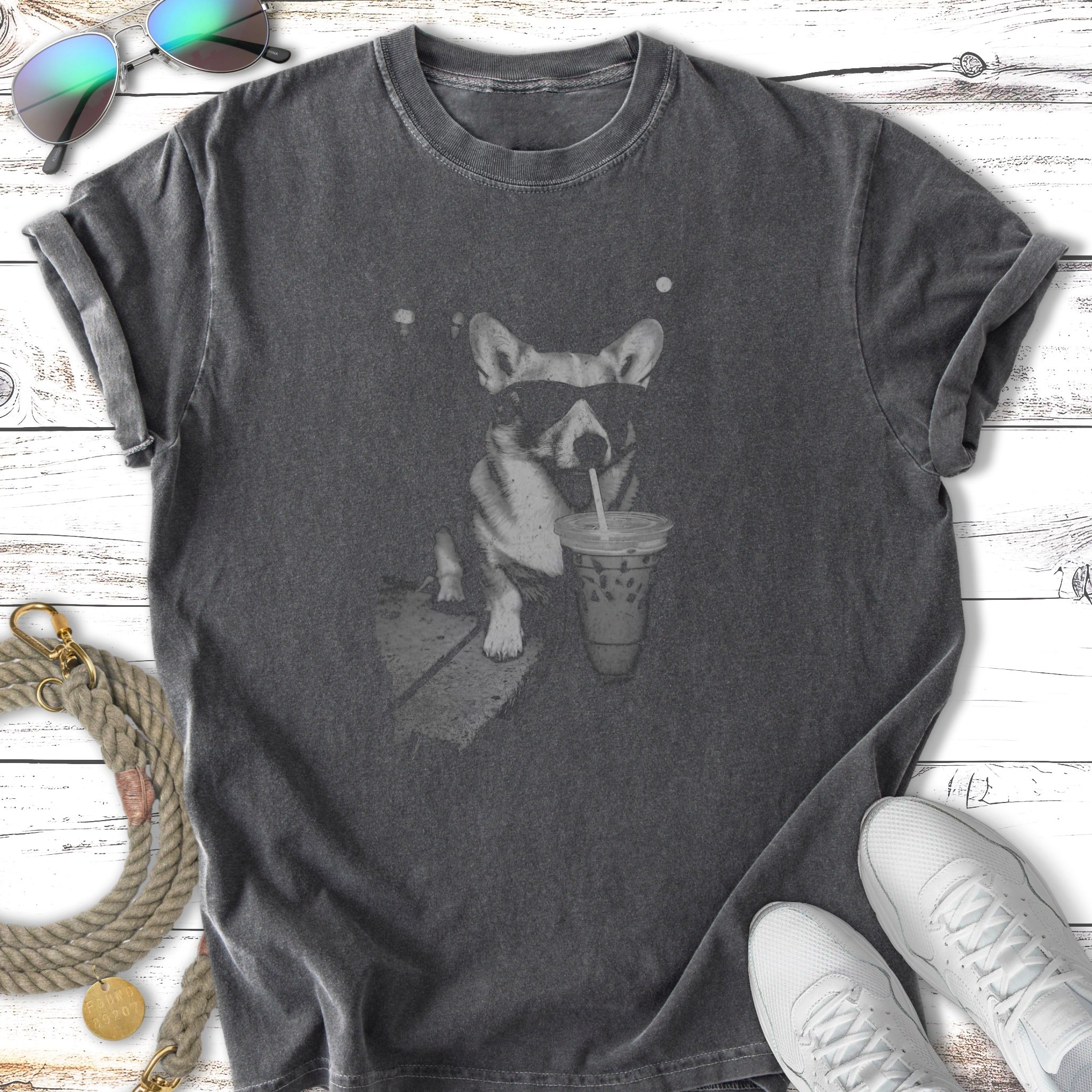 T-shirt featuring a vintage graphic of a corgi wearing sunglasses drinking iced coffee.