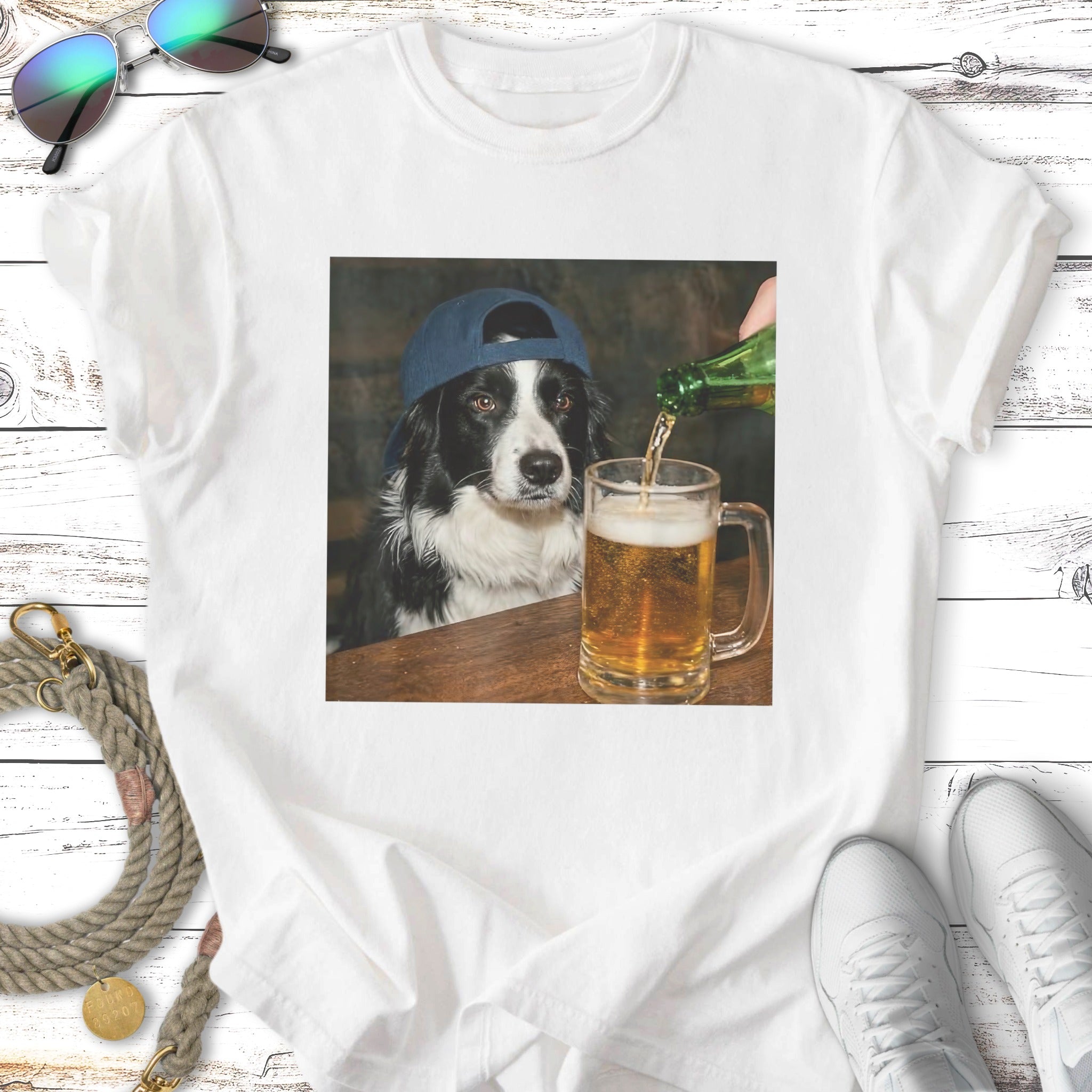 Black and white dog wearing a blue baseball cap, drinking beer.