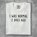 White t-shirt with "I WAS NORMAL 2 DOGS AGO" text.