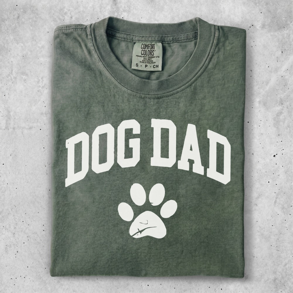 Green t-shirt with white "DOG DAD" text and paw print.