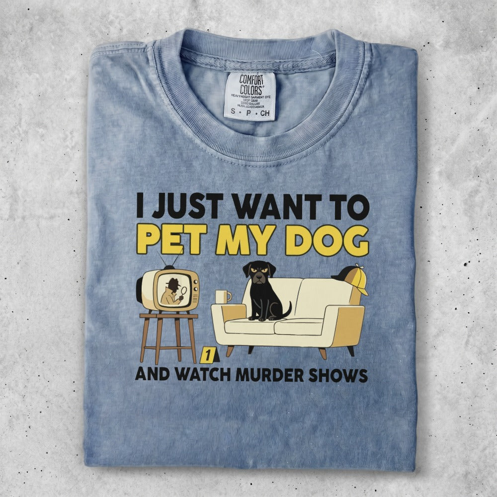 T-shirt with graphic of dog on couch watching TV and text "I just want to pet my dog and watch murder shows".