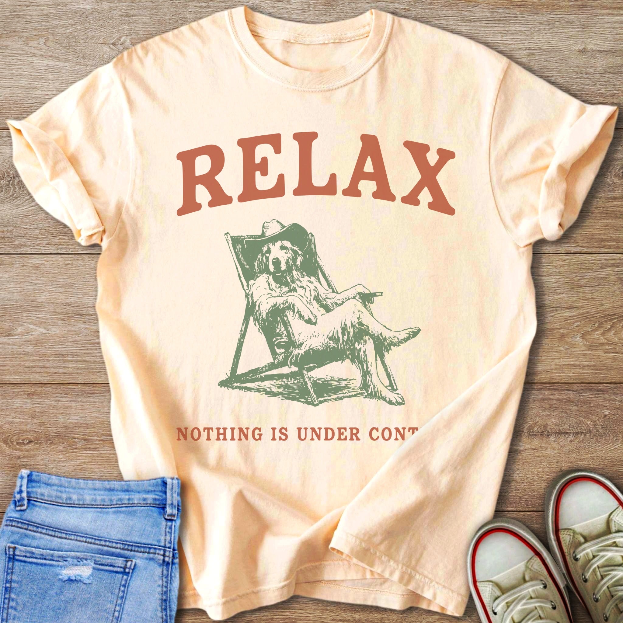 Peach t-shirt with "RELAX" and dog in a deck chair graphic.