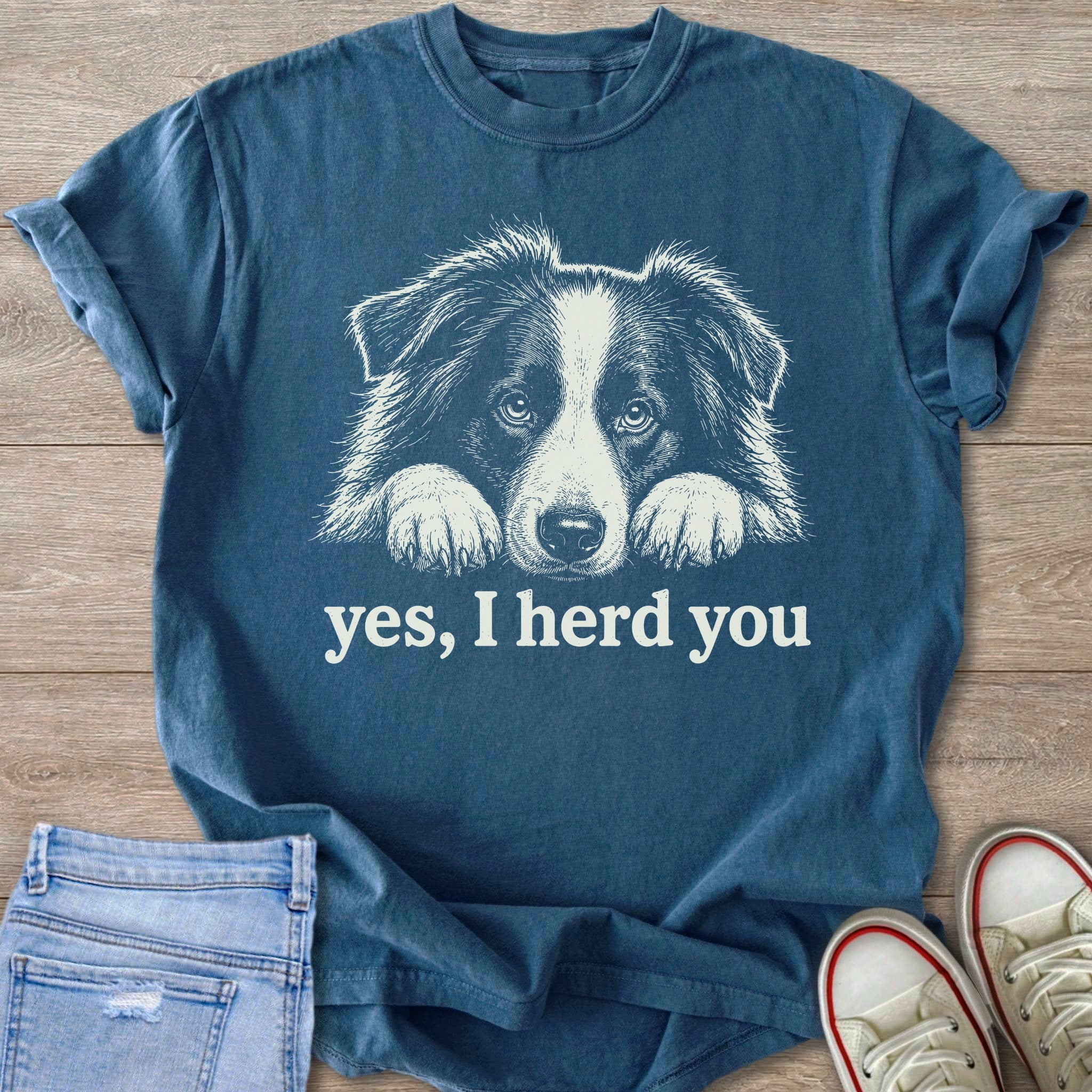 Blue t-shirt with white line art of a dog's face and text "yes, I herd you."