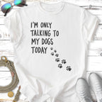 White t-shirt with black text "I'M ONLY TALKING TO MY DOGS TODAY" and paw prints.
