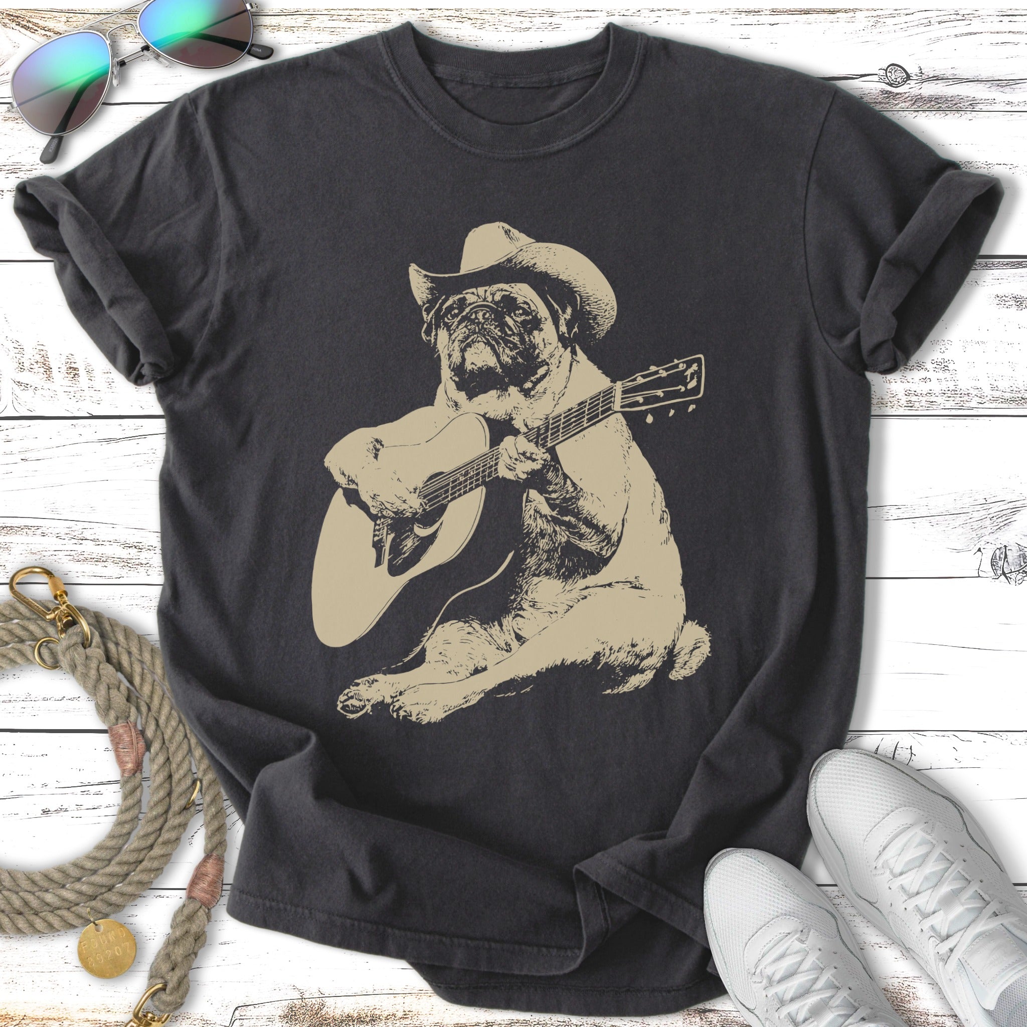 Pug wearing a cowboy hat plays guitar on a charcoal t-shirt.