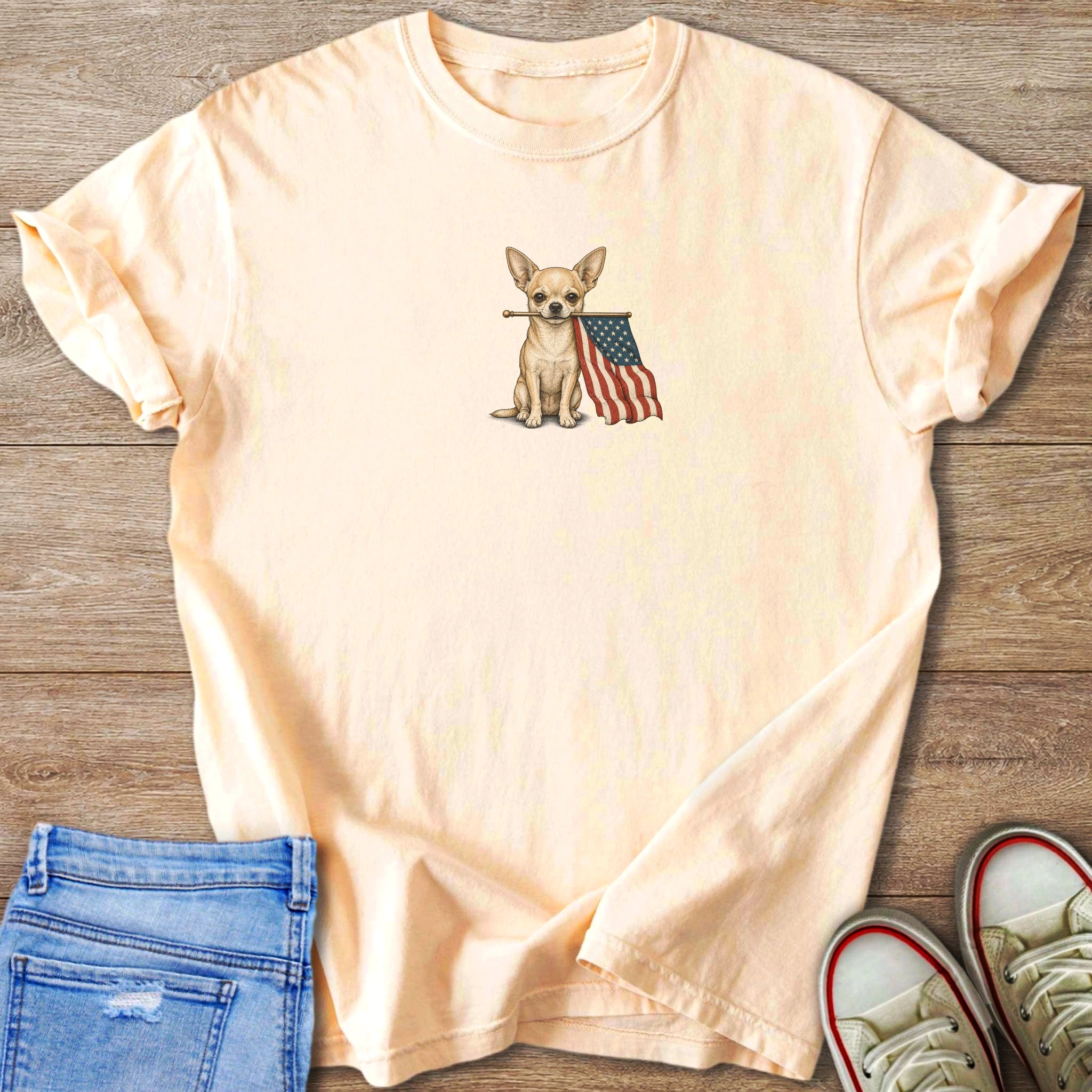 Peach t-shirt with a drawing of a chihuahua holding an American flag.
