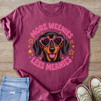 Raspberry t-shirt with a dachshund wearing heart sunglasses saying "More Weenies Less Meanies".