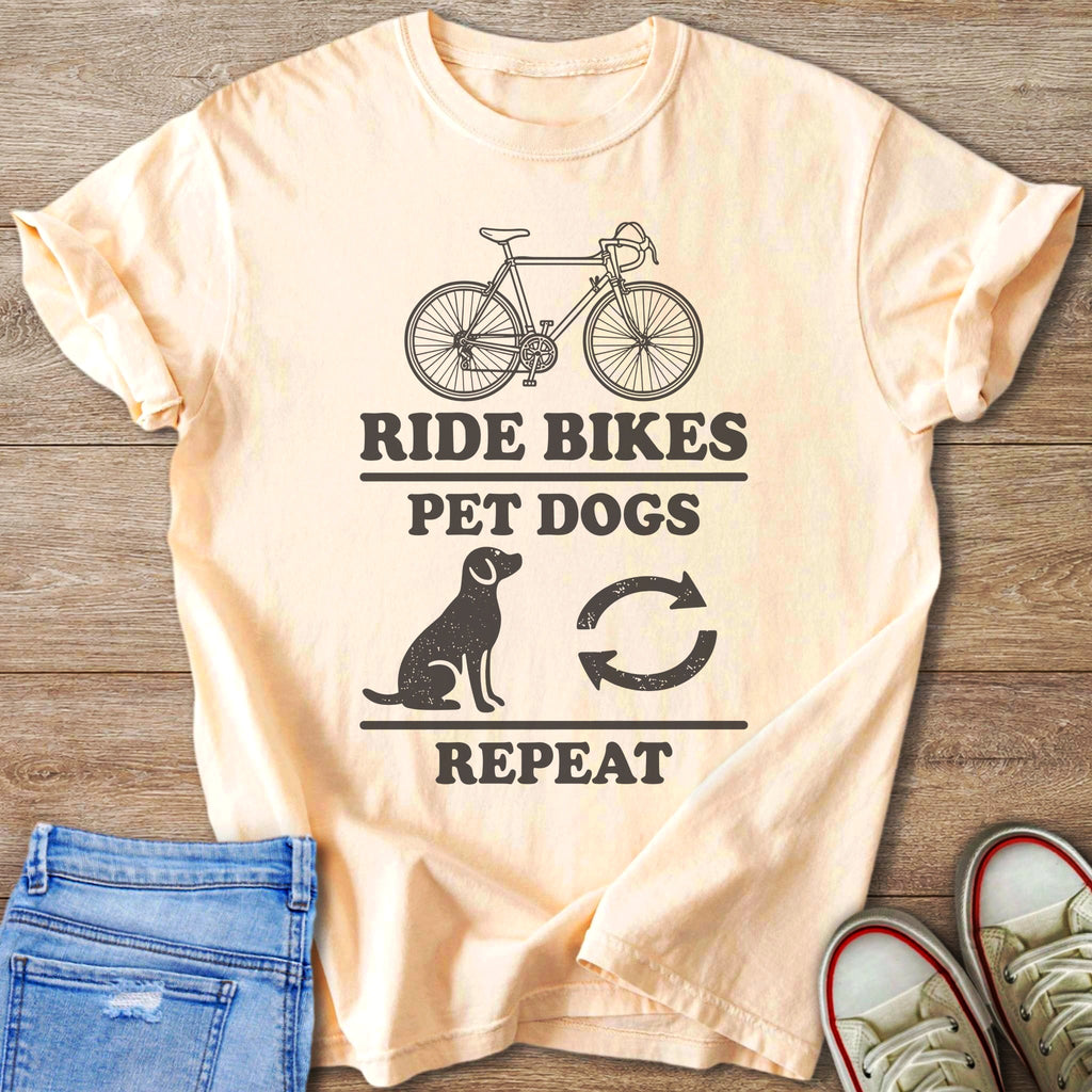 Peach t-shirt with "Ride Bikes Pet Dogs Repeat" graphic and biking symbols.