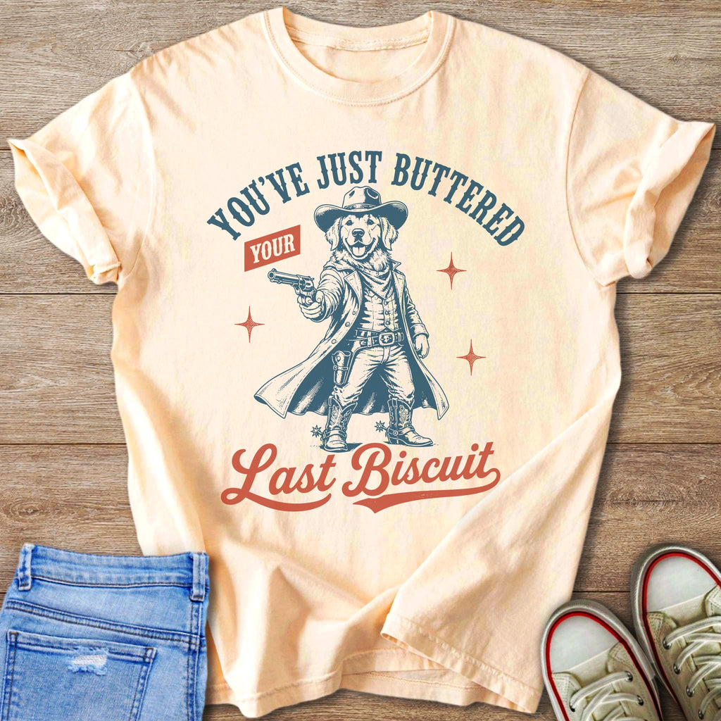 T-shirt graphic of a golden retriever dressed as a cowboy holding a gun.