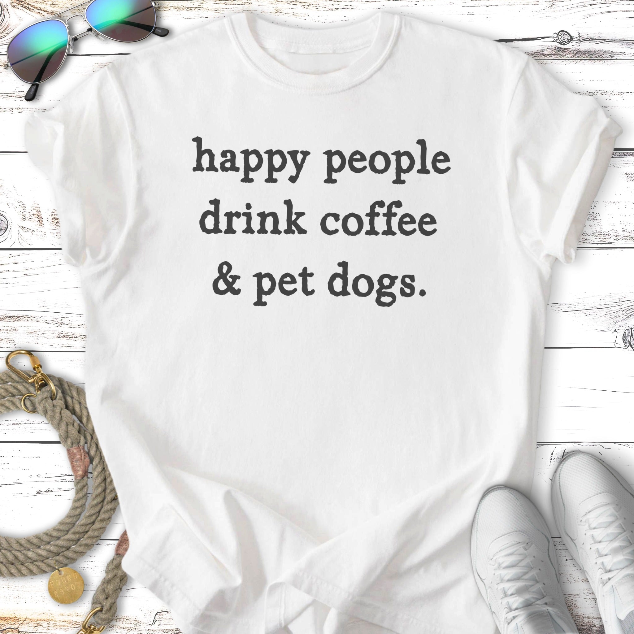 White t-shirt with "happy people drink coffee & pet dogs." text.