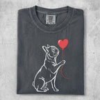 French bulldog holding a red heart balloon.