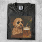 Dog wearing sunglasses sits by a mug of beer.