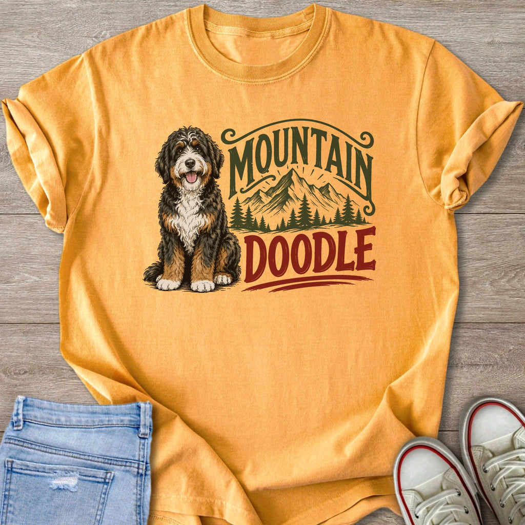 Bernedoodle dog with "Mountain Doodle" graphic on an orange t-shirt.