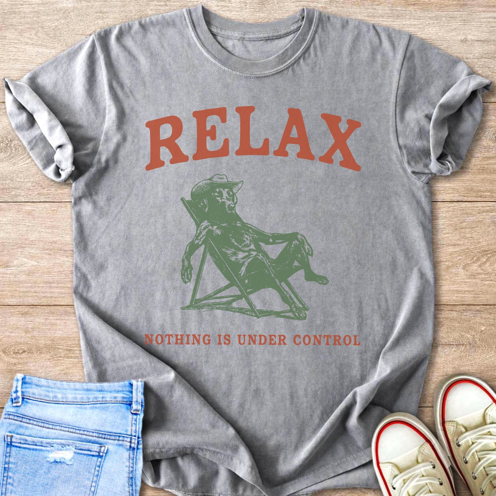 Gray t-shirt with a green graphic of a dog in a lounge chair and "RELAX NOTHING IS UNDER CONTROL" text.