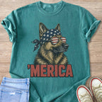 German Shepherd wearing American flag bandana and sunglasses with "MERICA" text.