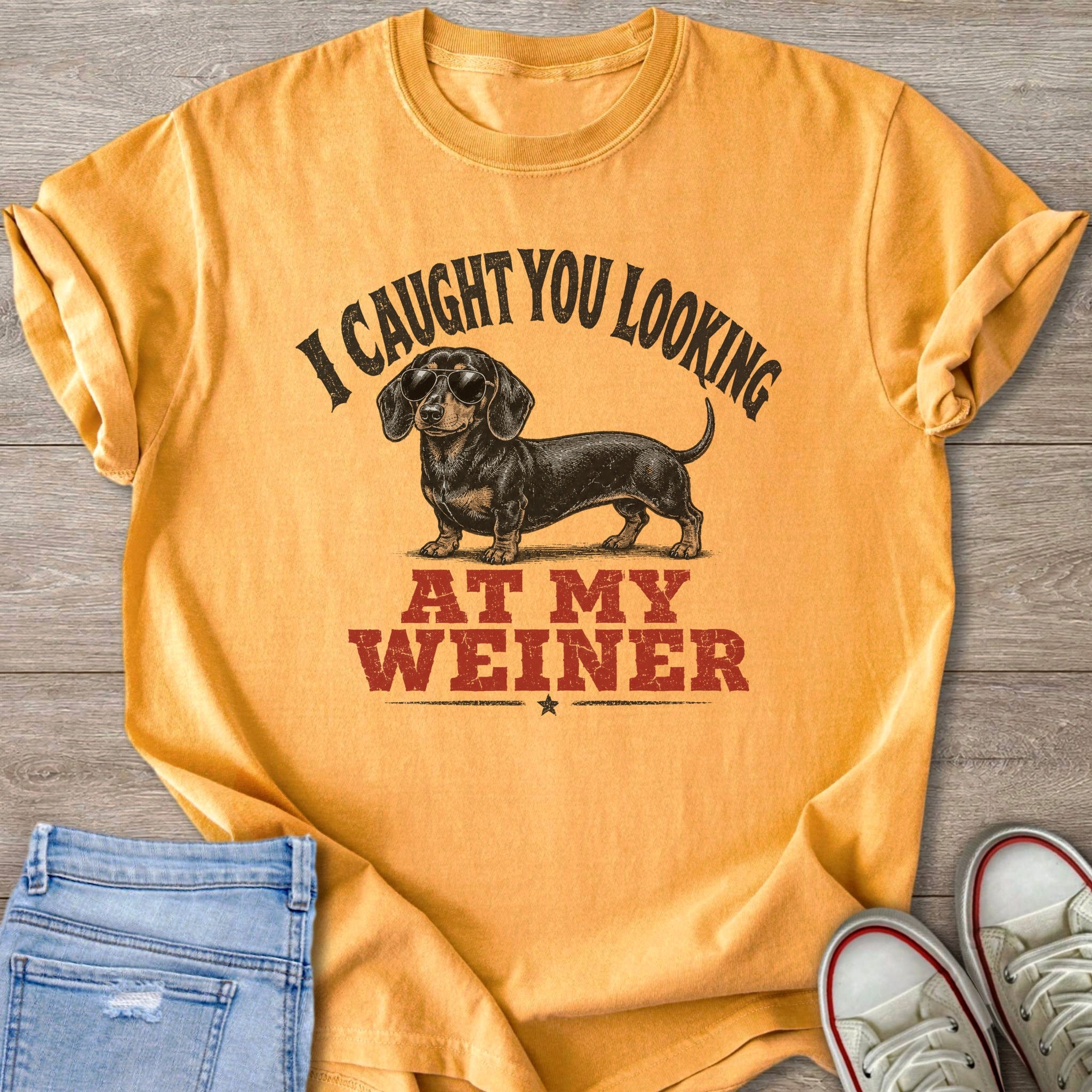 Yellow t-shirt with dachshund wearing sunglasses and text "I CAUGHT YOU LOOKING AT MY WEINER".