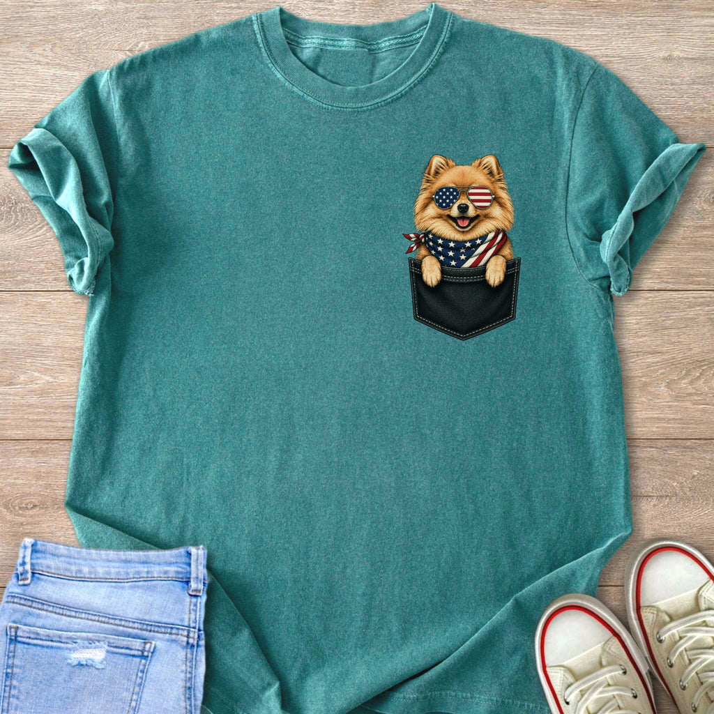 Teal t-shirt with a Pomeranian peeking from a black pocket, wearing American flag sunglasses and bandana.