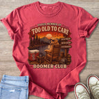 Proud member of Too Old To Care Boomer Club graphic on a red t-shirt.