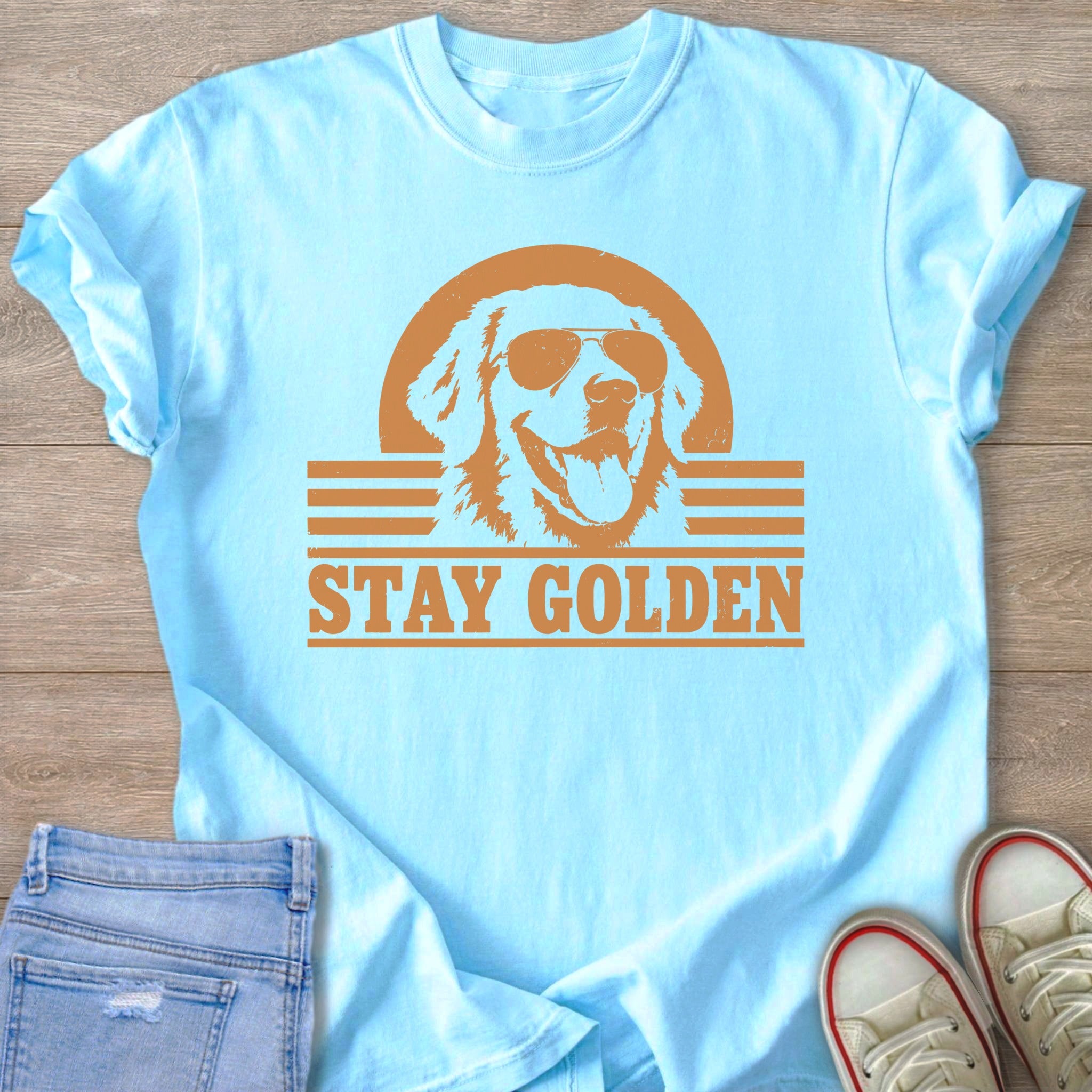 Light blue t-shirt with a distressed graphic of a golden retriever wearing sunglasses and text that reads "STAY GOLDEN".