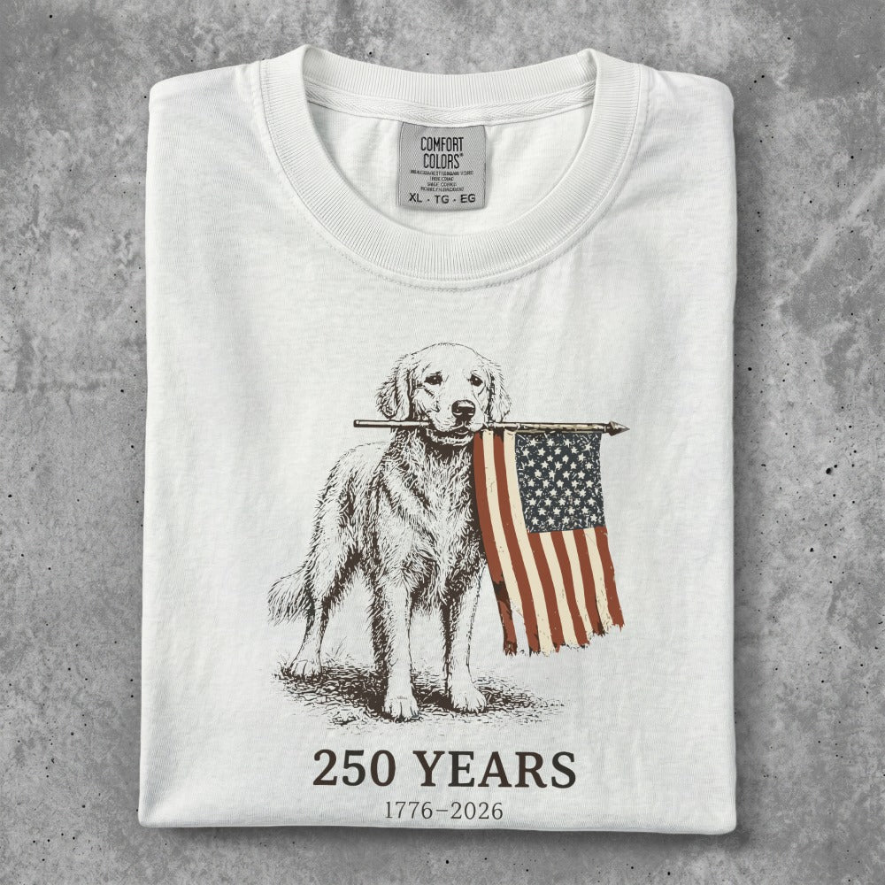 Golden retriever holding American flag on white t-shirt, "250 YEARS 1776-2026" text.
