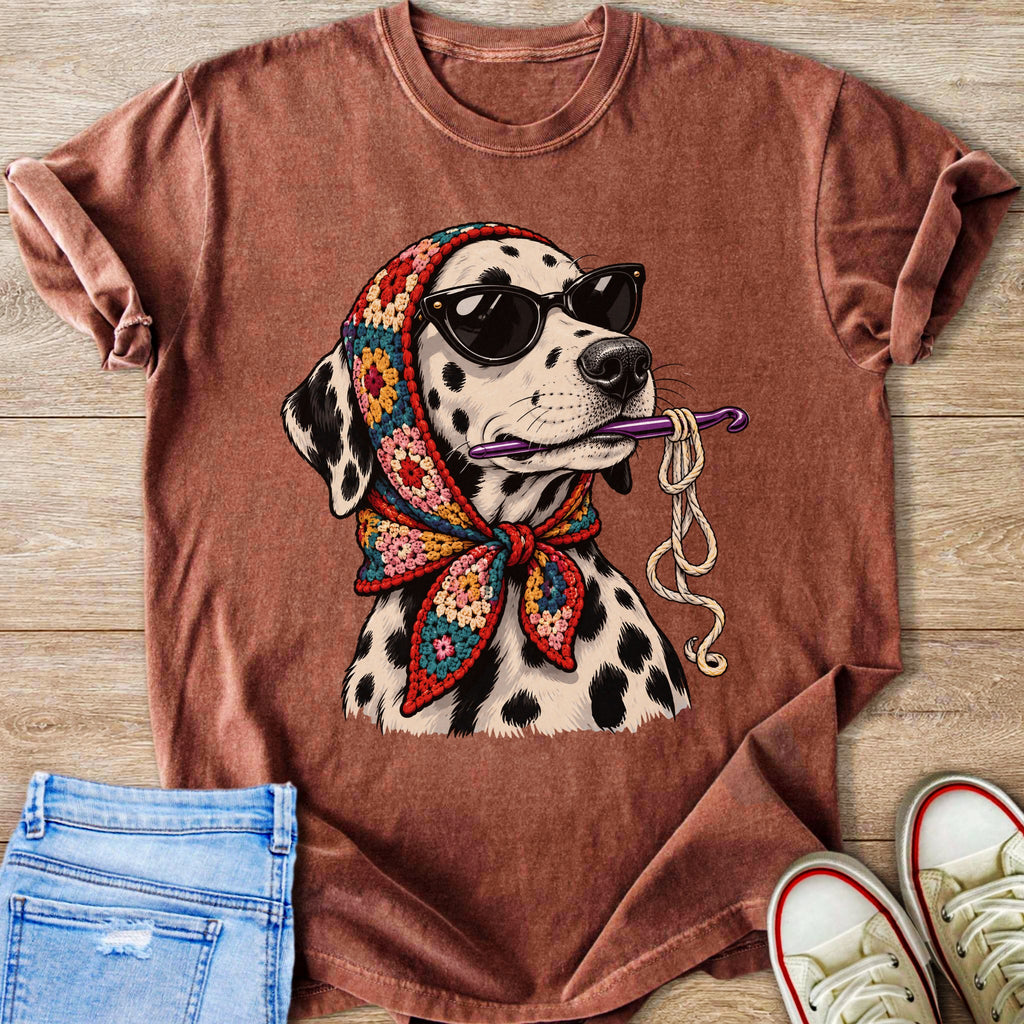 Dalmatian wearing sunglasses and crochet headscarf holding crochet hook and yarn.
