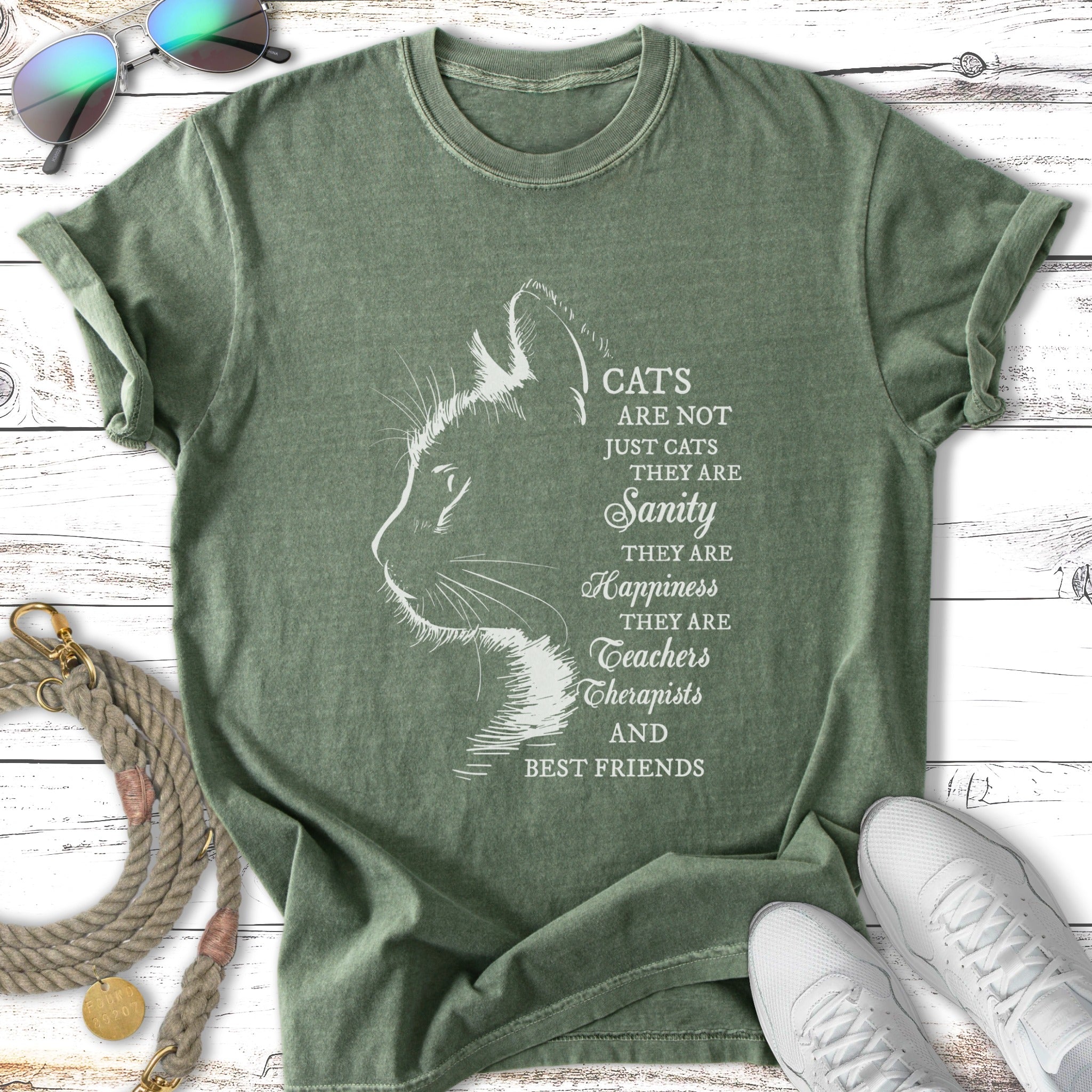 Green t-shirt with cat outline and text about cats being sanity, happiness, teachers, therapists, and best friends.