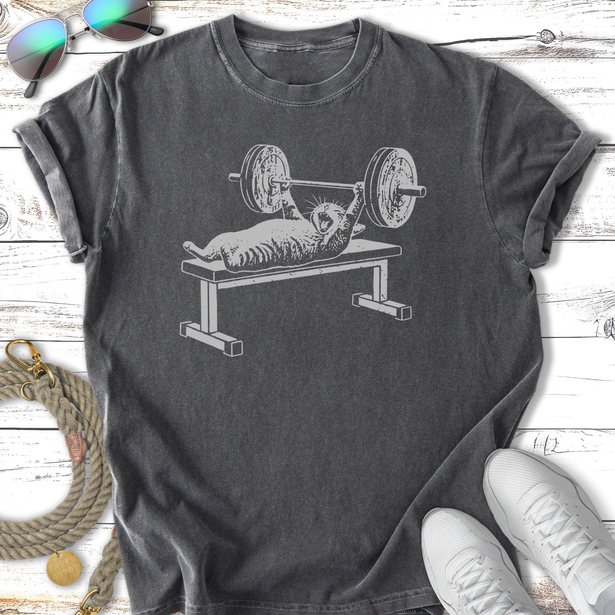 Cat bench pressing weights, vintage distressed graphic on a t-shirt.