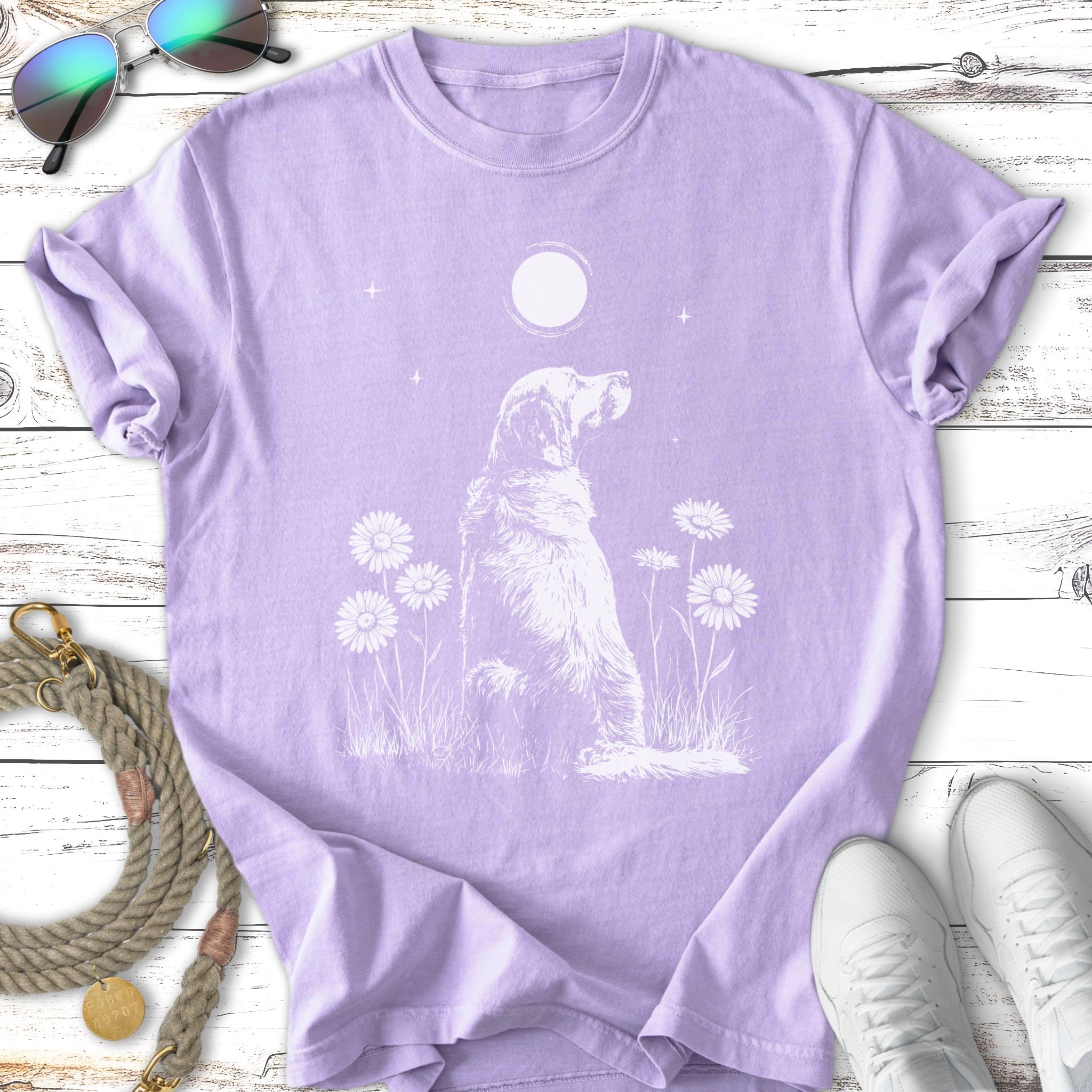 White line art of a golden retriever sitting among daisies under a moon.