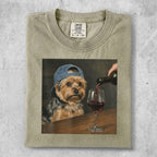 Dog wearing a blue baseball cap drinks red wine from a glass.