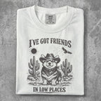 White t-shirt with corgi in cowboy hat, cacti, and text: I've got friends in low places.