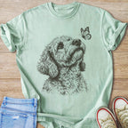 Light teal t-shirt with a black line drawing of a dog looking up at a butterfly.