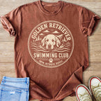 Golden Retriever swimming club graphic on a reddish brown t-shirt with text.