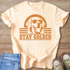 Peach t-shirt with distressed graphic of a golden retriever wearing sunglasses and the text "STAY GOLDEN".
