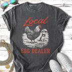 T-shirt graphic with chicken, cat, and barn; "Local Egg Dealer" text.