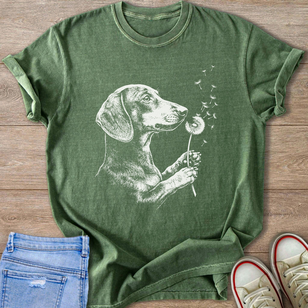 Green t-shirt with white sketch of dachshund inhaling a dandelion